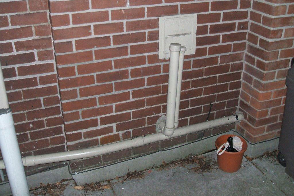 Above ground heating oil tank vent and fill piping. Notice the pipes go through the building wall and not into the ground.